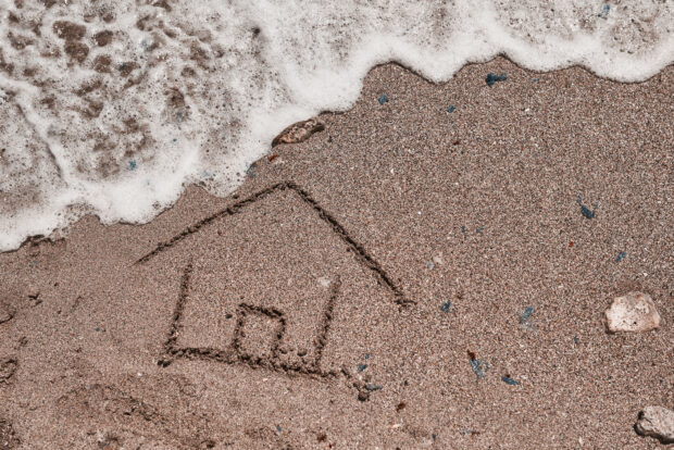 high angle view of house draw on the beach and wave coming over it.