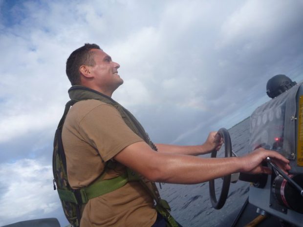 Andy Deary at the controls of a small boat.