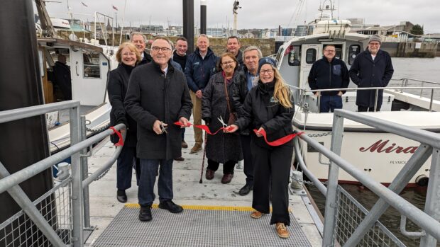 Group stood on pontoon gangway cutting a ribbon to open the Mayflower Pontoon in Plymouth